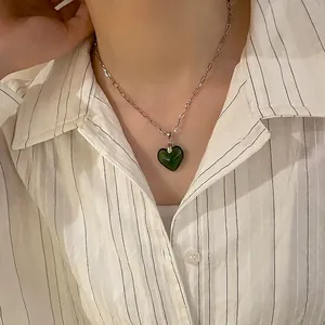Close-up of zebra pattern green heart pendant on stylish silver link chain