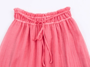 Detail of pink pleated skirt high elastic waist with decorative frill and drawstring bow