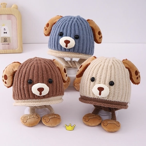 Three knit baby winter hats with puppy ear designs and cute bone-shaped baby tags
