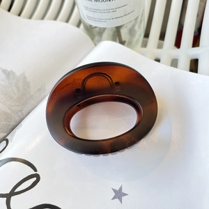 Detail view of oval tortoiseshell hair claw clip with item number 5635 on resin surface