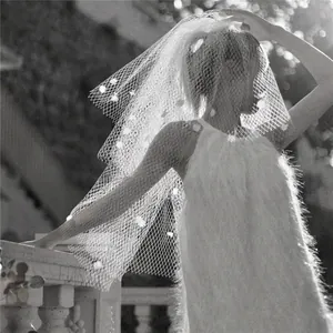 Close-up of vintage bridal birdcage veil with delicate 3D floral accents in black and white