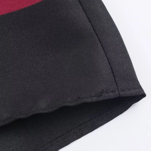Detail of red and black paisley wrap dress showing diagonal twill fabric and stitching