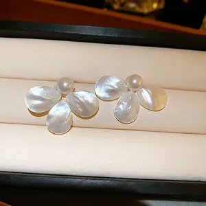 Elegant mother of pearl flower earrings with white pearls in a beige jewelry box