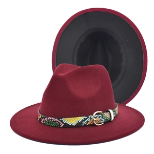 Detail of burgundy fedora hat with colorful snakeskin band and golden metal buckle