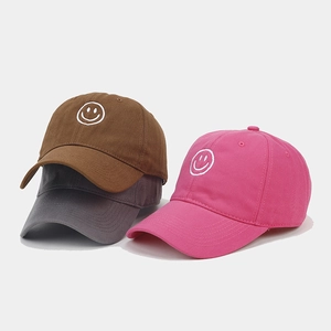 Three embroidered smiley baseball caps in brown, dark grey and rose red canvas