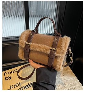 Close-up of brown plush and leather patchwork handbag with gold metal buckles and strap