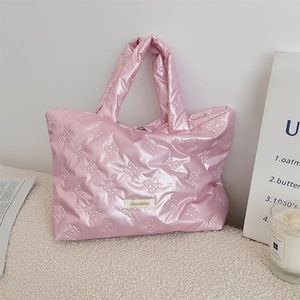 Detail view of pink quilted tote bag with bow relief pattern and Sorekka brand label