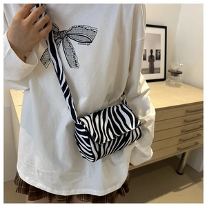 Close-up of zebra print crossbody bag showing textured fabric and stylish flap cover