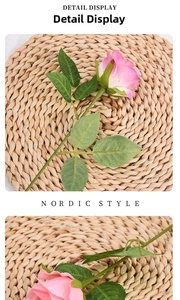 Macro detail of artificial rose with pink and white gradient petals and green leaves
