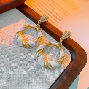 Vintage gold and white enamel twisted hoop earrings in a stylish spiral design