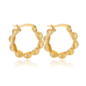 Detail of gold-tone U-shaped hoop earrings with textured bamboo-style shell pattern
