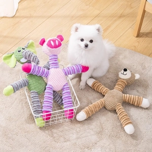 Three plush squeaky dog toys in a basket with a white puppy on a cozy rug