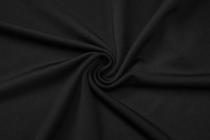 Detaillierte Makroansicht von schwarzem Spitzenstoff mit eleganten Spiralen und Falten