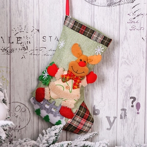 Detail of green plaid Christmas stocking with 3D reindeer doll and snowflake patterns