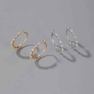 Close-up of gold and silver hoop earrings featuring sparkling pavé cubic zirconia inlay