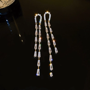 Elegant gold U-shaped drop earrings with long zircon tassels and sparkling starburst effects