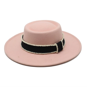Detail of pink wool boater hat featuring black grosgrain ribbon and white bead trim