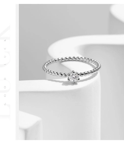 Detail of s925 silver beaded ring with a six-prong set round moissanite gemstone