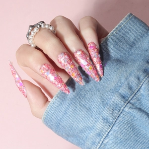 Detailed view of pink stiletto press-on nails with colorful sequins and glitters