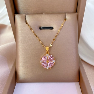 Elegant gold titanium necklace with pink clover pendant in a beige jewelry gift box