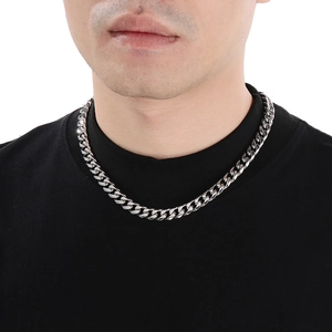 Close-up of polished silver stainless steel Cuban link necklace worn on male model