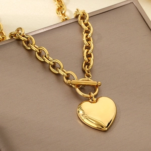 Detailed shot of gold-tone heart pendant necklace with OT toggle clasp on a display box