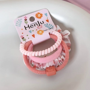 Détail d'un chouchou à fleurs roses et élastique spirale sur plateau céramique