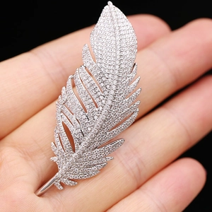 Detailed close-up of a zircon feather brooch featuring silver-tone metal and fine crystals