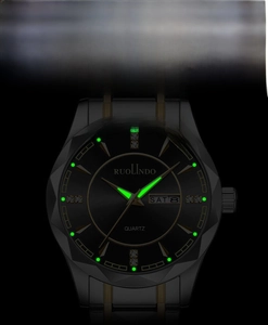 Detail of luminous watch hands and double calendar display on a faceted bezel black dial