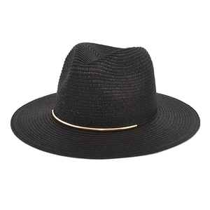Detail of black straw fedora hat featuring a stylish gold metal bar accent on the base