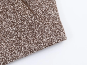 Detailed macro view of the brown and white flecked knit fabric with textured grain