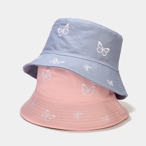 Close-up of butterfly embroidery details on blue and pink cotton reversible bucket hats