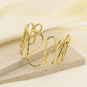 Irregular wavy open cuff bracelet in gold finish with a textured metallic surface