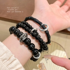 Close-up of three black obsidian beaded bracelets with silver accents on a woman's wrist