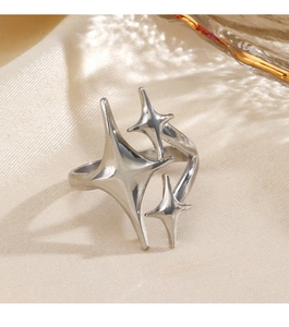 Detailed macro view of silver star starburst open ring on silk fabric background