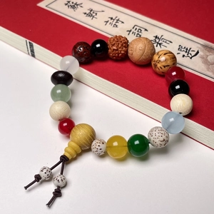 Close-up of mixed bodhi seed bracelet with colorful agate beads and a yellow gourd charm