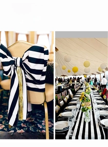 Detail of black and white striped table runner and chair sashes with golden tassels