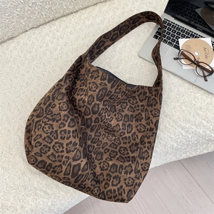 Detailed top view of leopard print tote bag with laptop and office accessories