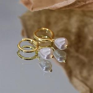 Close-up of S925 sterling silver gold-plated hoop earrings with natural baroque pearl charms