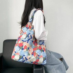 Detail view of large canvas tote bag with vintage floral oil painting pattern on shoulder