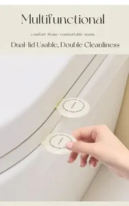 Hygienic cream white toilet lid lifter with minimalist round design and adhesive back