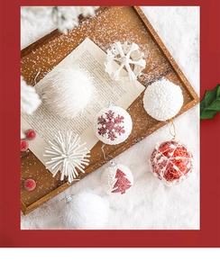 Detailed overhead view of varied white and red Christmas ornaments on a rustic tray