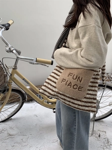 Winter fuzzy tote bag detail with FUN PLACE embroidery on striped sherpa fleece texture
