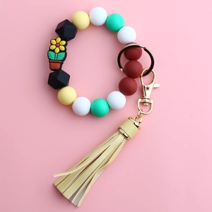 Detail of silicone beaded keychain bracelet with flower pot pendant and yellow tassel