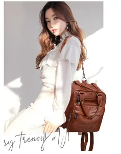 Detail view of brown soft leather backpack with triple zipper pockets and metal hardware