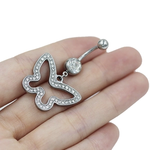 Detail showing hand holding a crystal bowknot navel ring in polished silver steel
