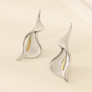 Close-up of elegant silver lily-shaped earrings with golden pistils on white background