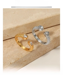 Detailed macro view of heart zircon rings with spiral texture on beige stone surface