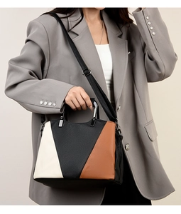 Close-up of tricolor tote with metal handle and pebble leather texture on a model