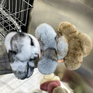 Close-up of hand holding plush rex rabbit fur hair claws in various colors